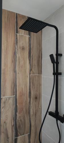 une douche dans une salle de bain avec un mur en bois dans l'établissement Lodge Loupau Maga, à Luchon