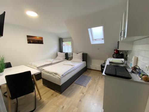 Habitación pequeña con cama y escritorio. en Apartment Q im Zentrum von Königsbronn en Königsbronn