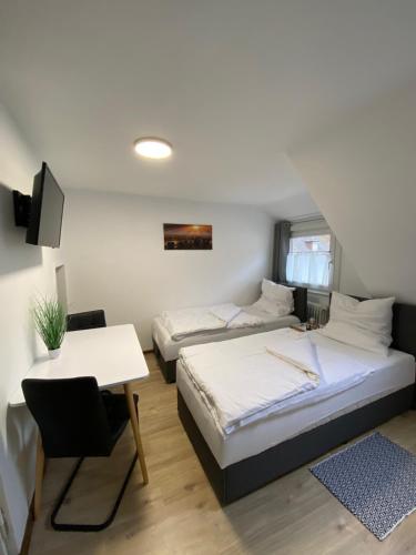 a bedroom with two beds and a table and a desk at Apartment Q im Zentrum von Königsbronn in Königsbronn