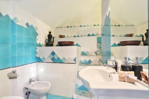a blue and white bathroom with a sink and a toilet at MaryLou by DomusAway in Monte Petrosu