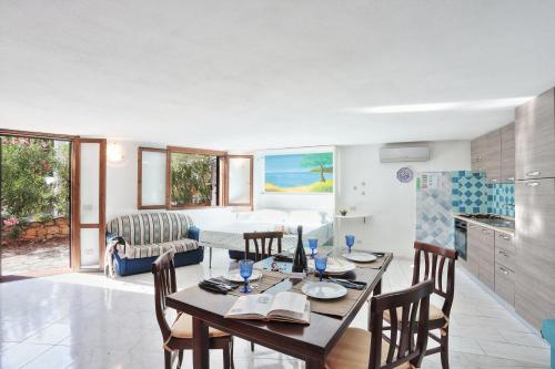 Una cocina y una sala de estar con mesa y sillas. en MaryLou by DomusAway, en Monte Petrosu