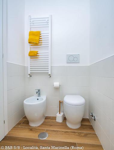 a white bathroom with a toilet and a sink at CINQUE OTTAVI B&B in Santa Marinella