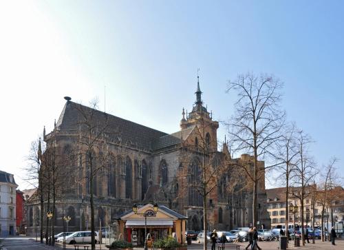 a large church with a clock tower in front of it at HYPER CENTRE - Colmar Cathédrale - PARKING Gratuit in Colmar