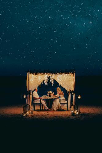 a couple sitting at a table under a tent at Villa Lala in Kiwengwa