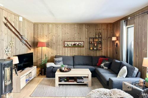 sala de estar con sofá azul y TV en New apartment Hafjelltoppen ski inout, en Hafjell