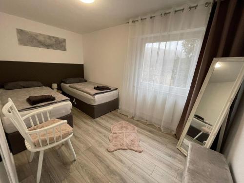 1 Schlafzimmer mit 2 Betten, einem Spiegel und einem Stuhl in der Unterkunft Natalie in Münsingen
