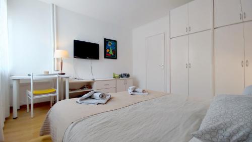 a bedroom with a bed and a desk and a television at Central point in Zagreb