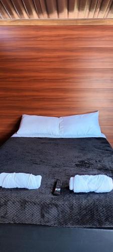 a bedroom with a bed with a wooden head board at Lagunero Trek B&B in Mesetas