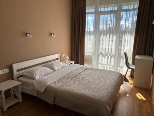 a bedroom with a bed and a large window at AvalonRestApartments in Lviv