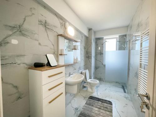 a white bathroom with a toilet and a shower at Twins in Suceava