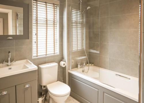 a bathroom with a toilet and a tub and a sink at Thirlestane Woodland Lodges in Lauder