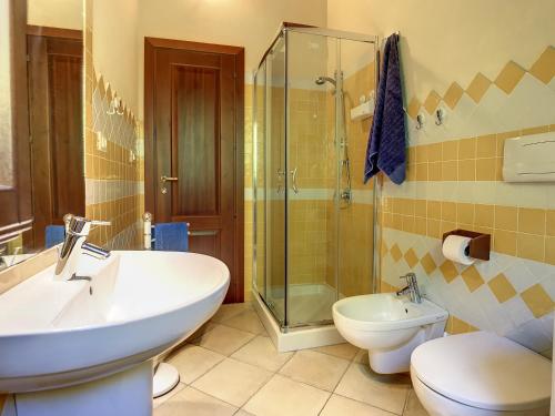 La salle de bains est pourvue d'un lavabo, de toilettes et d'une douche. dans l'établissement Grazioso attico vicino alla spiaggia e al centro, à Castelsardo