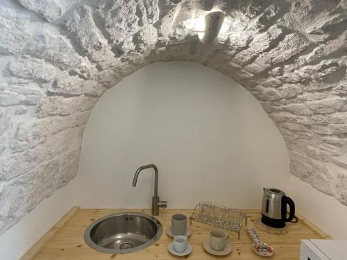 a kitchen with a sink in a brick wall at La quiete in Ceglie Messapica