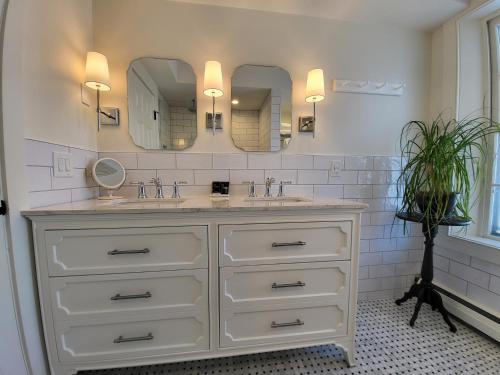 a bathroom with a sink and two mirrors at The Stowe Village Inn in Stowe