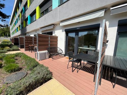 a patio with a table and chairs in front of a building at Lila Apartman in Balatonföldvár