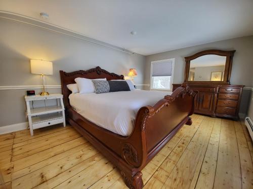 a bedroom with a large bed and a mirror at The Stowe Village Inn in Stowe