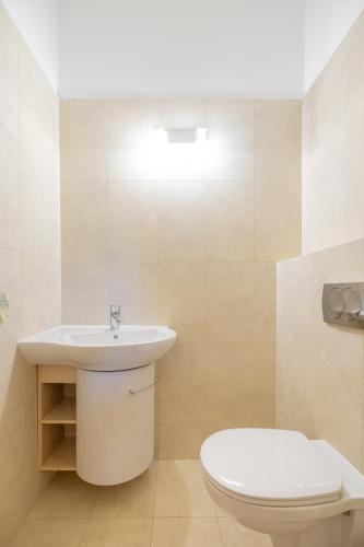 a bathroom with a white sink and a toilet at Apartamenty Vincent Sopot in Sopot