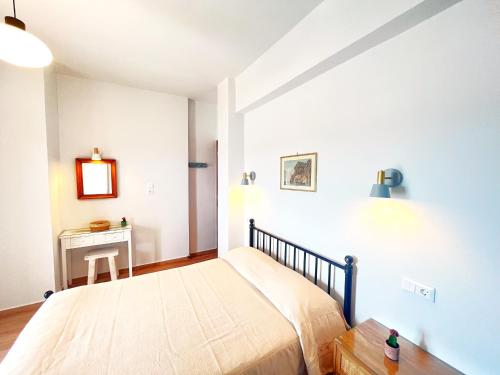a bedroom with a large bed and a table at Pefkakia Park in Ermoupoli