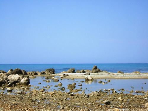 a beach with rocks and the ocean in the background at Punta Grande - Scala dei Turchi in Realmonte