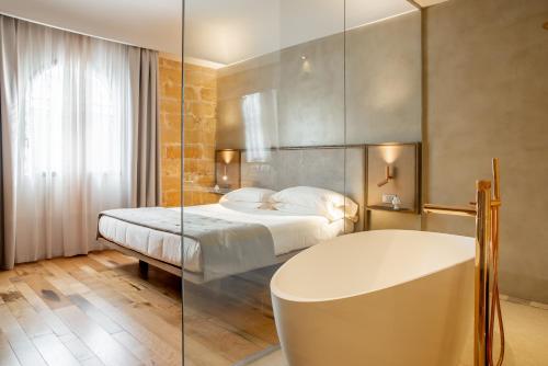 a bedroom with a bed and a tub in it at Villa Favorita Hotel & Events in Marsala