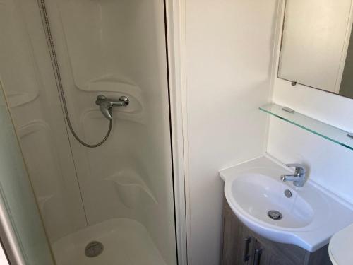 La salle de bains est pourvue d'une douche et d'un lavabo. dans l'établissement Mobile home 3 chambres Camping Cœur de Vendée 3 étoiles, à La Boissière-de-Montaigu