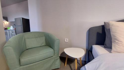 a green chair in a room with a bed and a table at Jimmy's place in Artemida