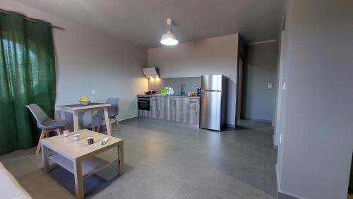 eine Küche mit 2 Tischen und einem Kühlschrank aus Edelstahl in der Unterkunft Jimmy's place in Artemida