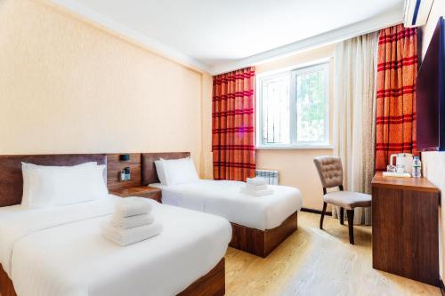 Pokój hotelowy z 2 łóżkami i krzesłem w obiekcie CENTRAL ASİA HOTEL w Taszkiencie