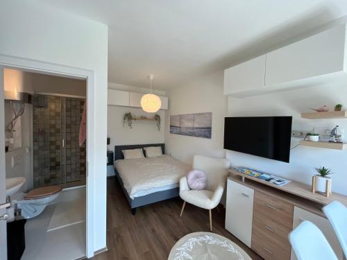 sypialnia z łóżkiem i telewizorem w pokoju w obiekcie Lila Apartman w Balatonföldvárze
