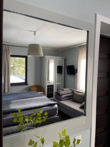 a mirror reflecting a bedroom with a bed and a couch at Bergbach in Ramsau
