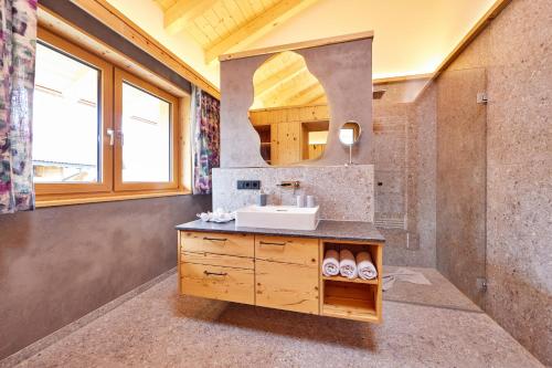 uma casa de banho com um lavatório e um espelho em Bichl Ferienwohnungen em Krün