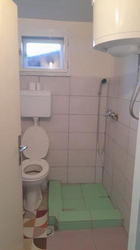 a bathroom with a toilet and a window at Kućerak in Irig