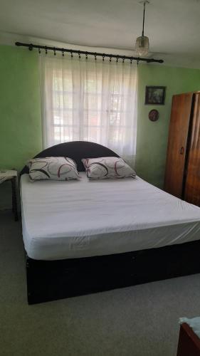 a large bed in a bedroom with a window at Kućerak in Irig