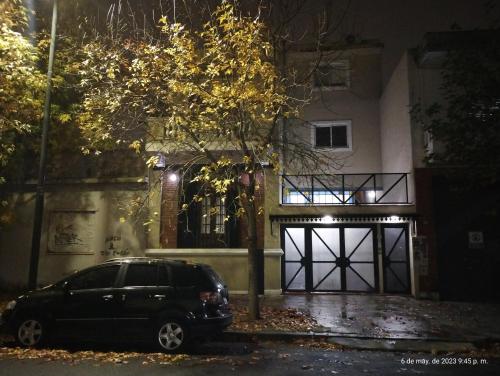 a black car parked in front of a house at night at COMO EN CASA en Buenos Aires in Buenos Aires