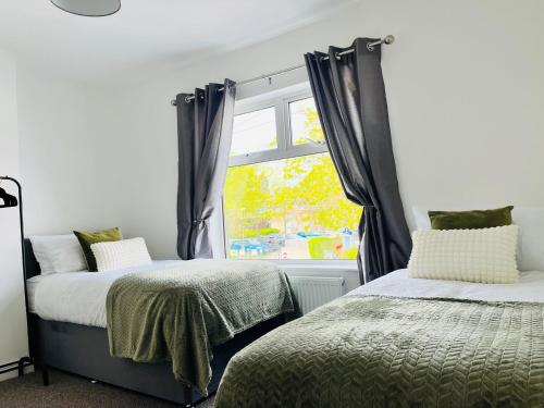 1 dormitorio con 2 camas y ventana en House for Contractors and Families, en Aldershot