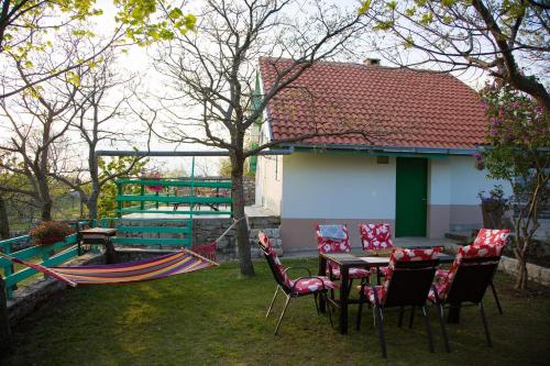 a patio with a table and chairs and a hammock at Vila Agroturizam Kućica Mostar-Welcome bikers in Mostar