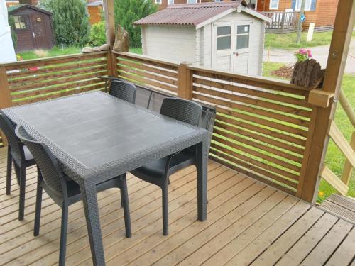 a table and chairs on a wooden deck at Grand Mobil Home 6 personnes climatisé avec 3 chambres et 2 salles de bains à Munster en Alsace in Munster