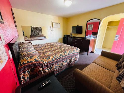 ニューオーリンズにあるRoyal Palms Motelのベッドとソファ付きのホテルルーム