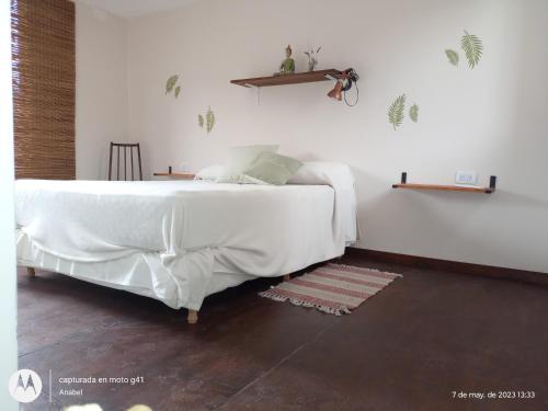 ein Schlafzimmer mit einem großen Bett mit weißer Bettwäsche in der Unterkunft Cabaña Colinas Verdes La Tamarita Sierra de los Padres in Mar del Plata