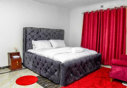 Schlafzimmer mit einem großen Bett und roten Vorhängen in der Unterkunft Sparkle Homes 