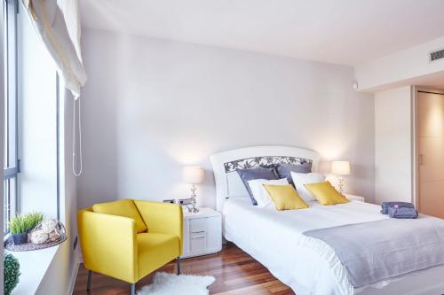 um quarto com uma cama e uma cadeira amarela em Sweet Inn - Paseo de Gracia - City Centre em Barcelona