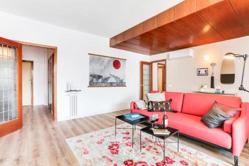 sala de estar con sofá rojo y mesa en Sweet Inn - Eixample Borrell, en Barcelona