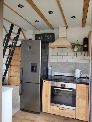 een keuken met een roestvrijstalen koelkast en een fornuis bij Widokowy Raj Piękny Widok!! in Międzybrodzie Bialskie