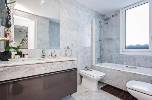 a bathroom with a sink and a toilet and a tub at Sweet Inn - Cosy Ciutadella in Barcelona