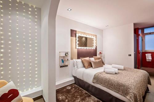1 dormitorio con 1 cama grande con luces en la pared en Sweet Inn - Urqui City Center, en Barcelona