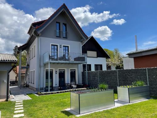 a white house with a fence in a yard at Quartier 22 in Kurort Steinbach-Hallenberg