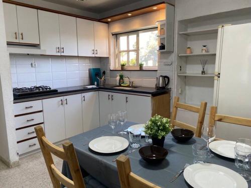 een keuken met een tafel met borden en glazen erop bij Уютная квартира с двумя спальными in Qiryat H̱ayyim