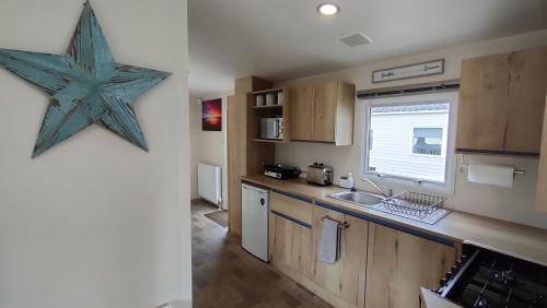 a kitchen with a starfish hanging on the wall at 3 Bedroom Stylish Caravan - Vans With Business Sign Not Allowed in Port Seton