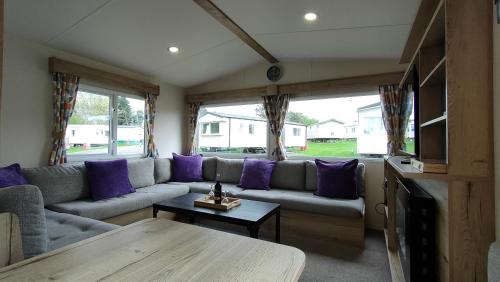 ein Wohnzimmer mit einem Sofa und einem Tisch in der Unterkunft 3 Bedroom Stylish Caravan - Vans With Business Sign Not Allowed in Port Seton