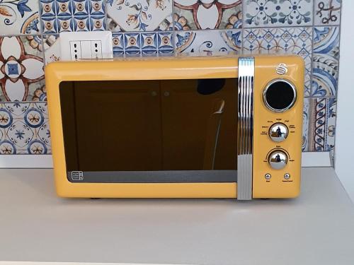 un forno giallo a microonde seduto sopra una parete di Casa Rossella a Procida